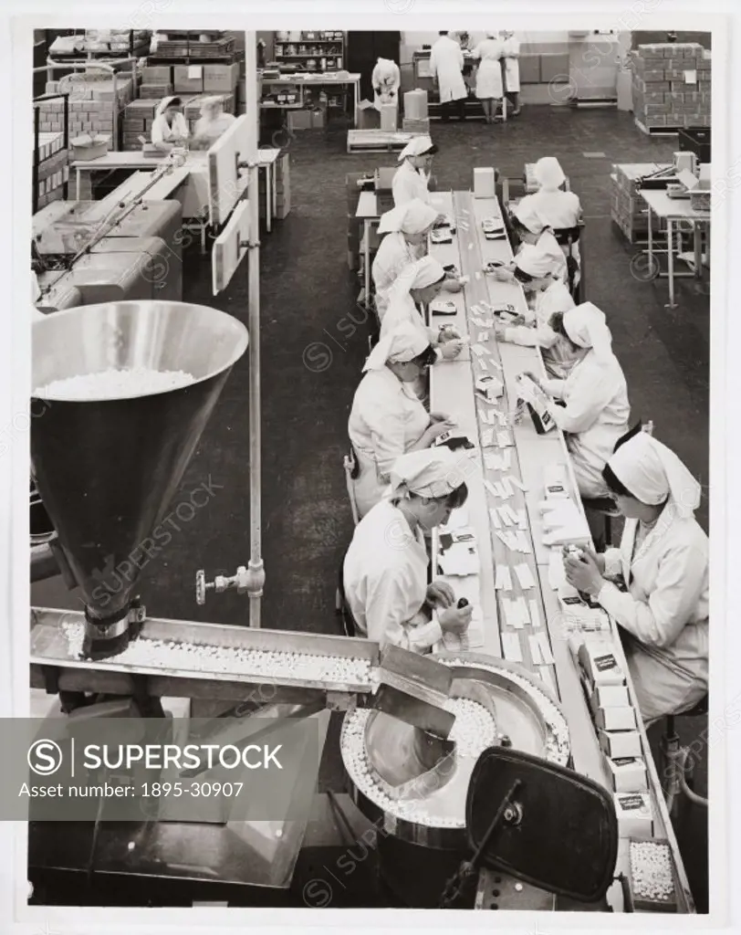 A photograph of workers on a factory line packing tablets, taken by an unknown photographer for The Sun newspaper in 1966. The women are working on an...