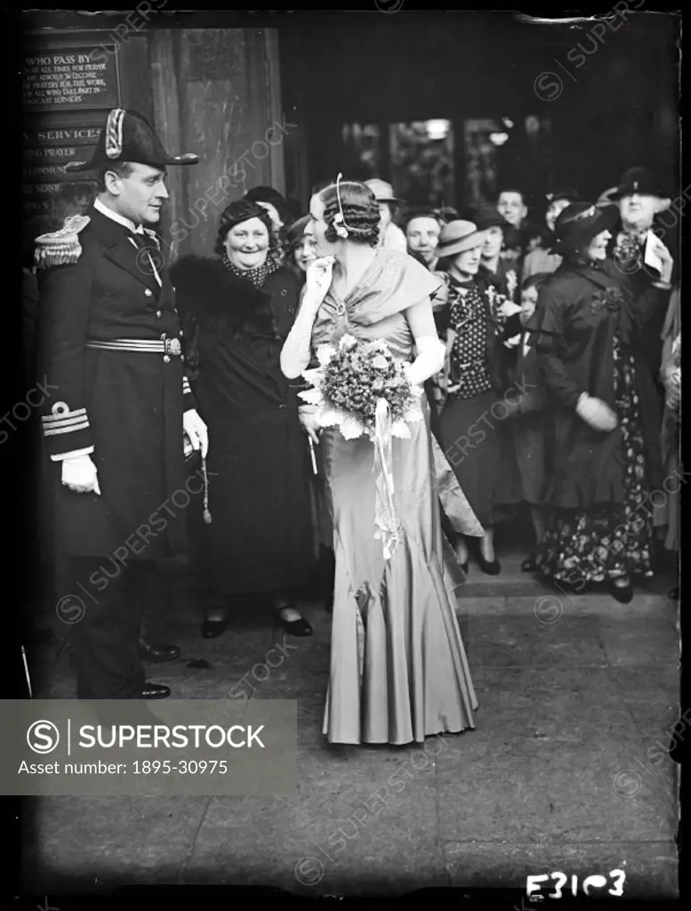 A photograph of a wedding held taken by Tomlin for the Daily Herald newspaper on 2 April, 1935. In military weddings, a guard of honour in uniform sta...