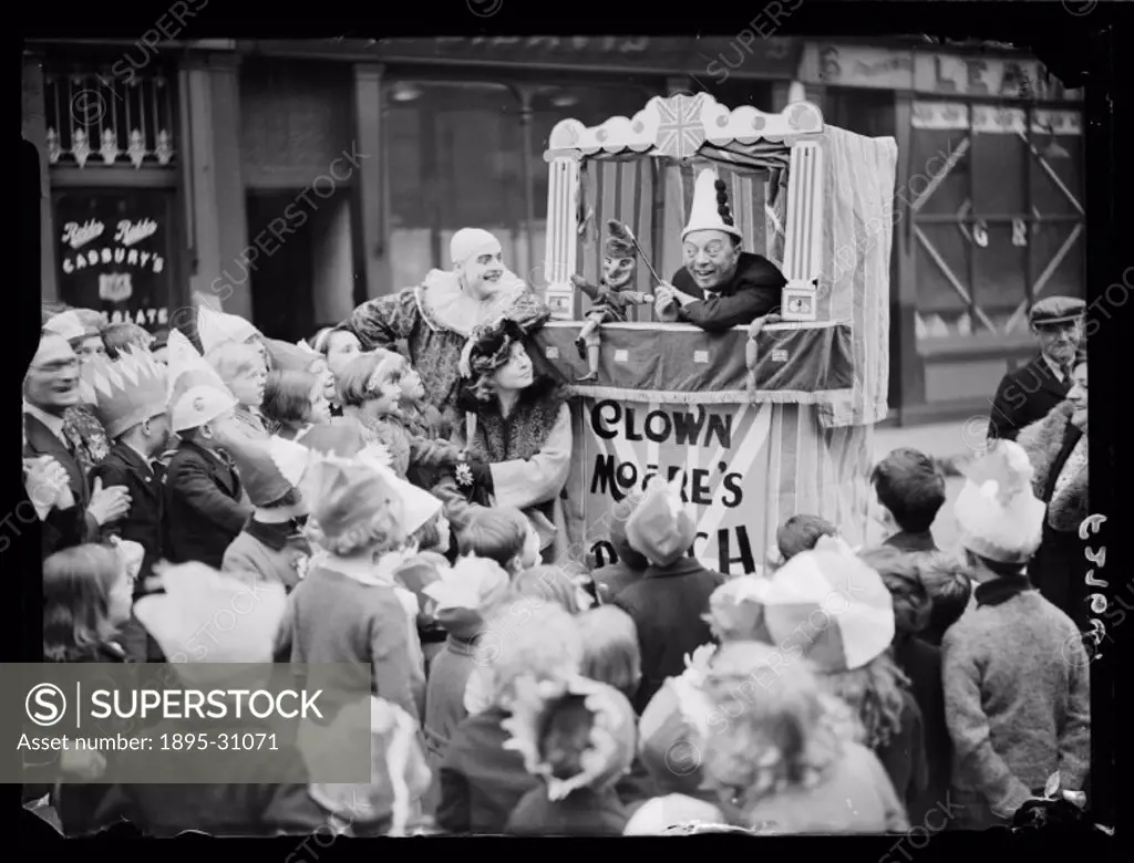 A photograph of a Punch and Judy Show for children at a Coronation tea party on Blenheim Terrace in St John´s Wood, London, taken by Saidman for the D...