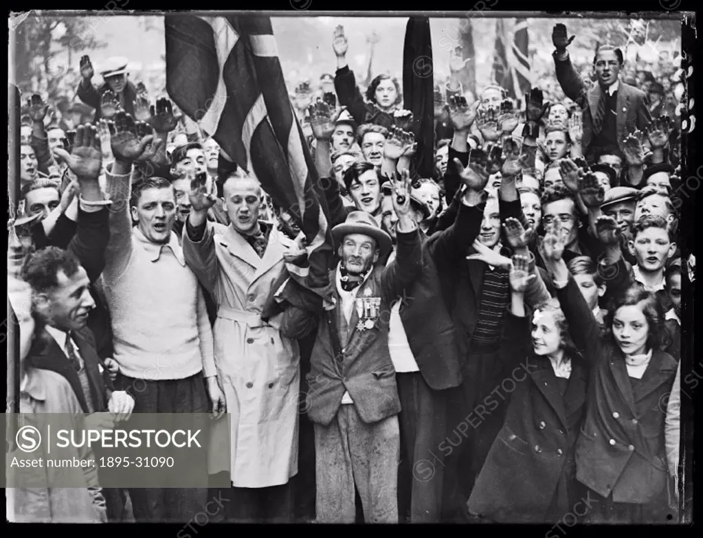 A photograph of a crowd of fascist supporters in Wood Street, Millbank, London, giving the Nazi salute for the camera, taken by Roper for the Daily He...