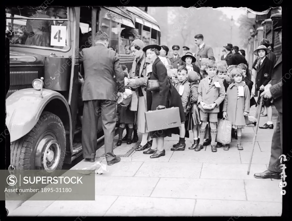 Group of school children queuing for the evacuation busThese evacuees, carrying a few possessions in brown-paper parcels and bags, are moving for safe...