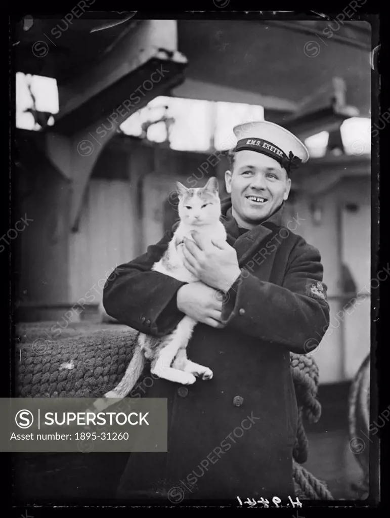 Sailor from HMS Exeter holding Pincher - ship´s cat and mascot . HMS Exeter took part in the battle which resulted in the sinking of the German battle...