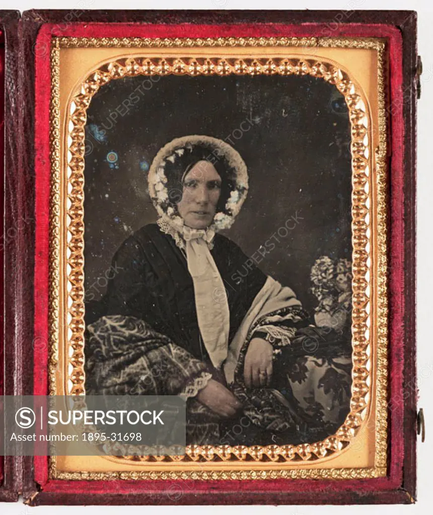 A hand-coloured daguerreotype portrait of a rather severe-looking woman in bonnet and shawl, taken by an unknown photographer in about 1855. In 1839, ...