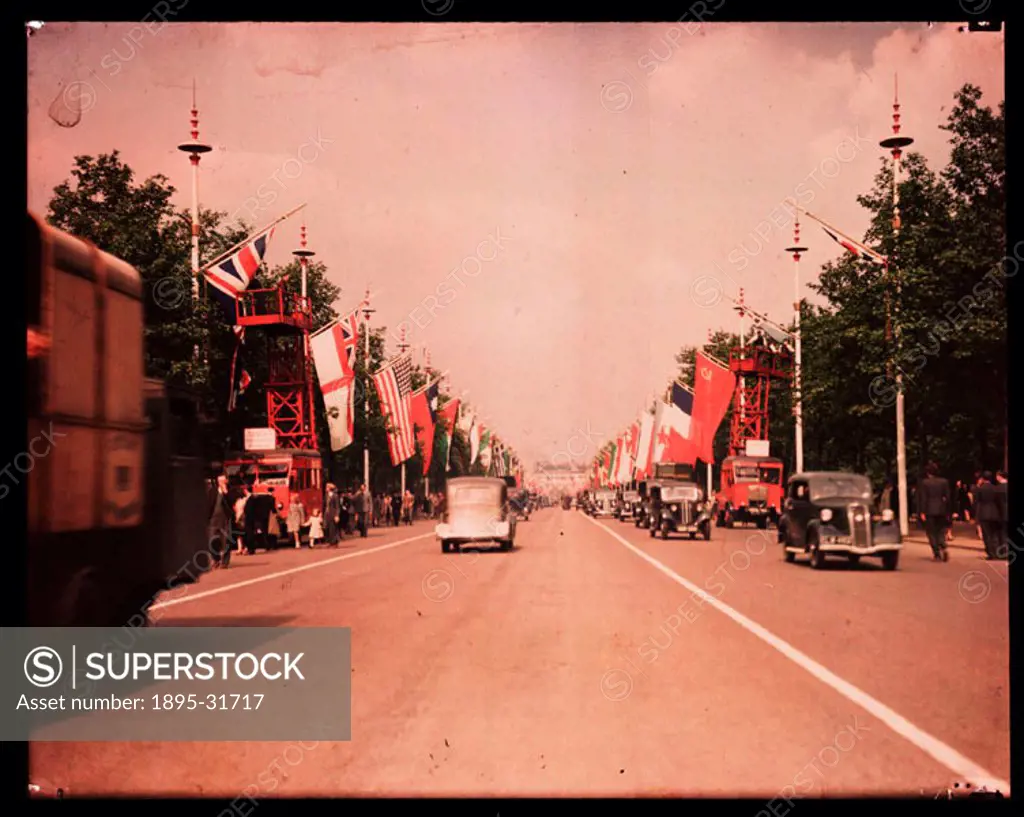 A Dufaycolor colour transparency, taken by an unknown photographer in 1945. The Mall is decorated with the flags of the Allied Powers, part of the cel...