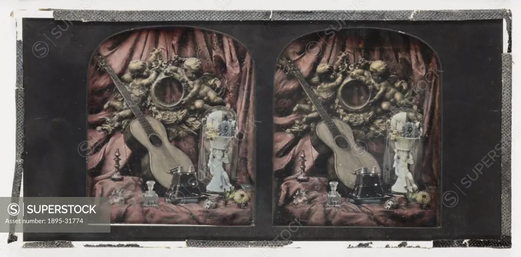 A hand-coloured stereoscopic daguerreotype of a still life, including a guitar, a carving of two cherubs, a small cased sculpture, flowers, vase and a...