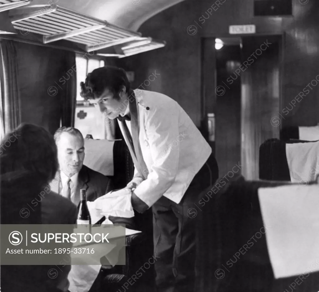 Brian Vaughan, steward, serving wine to passengers, 15 October 1971.