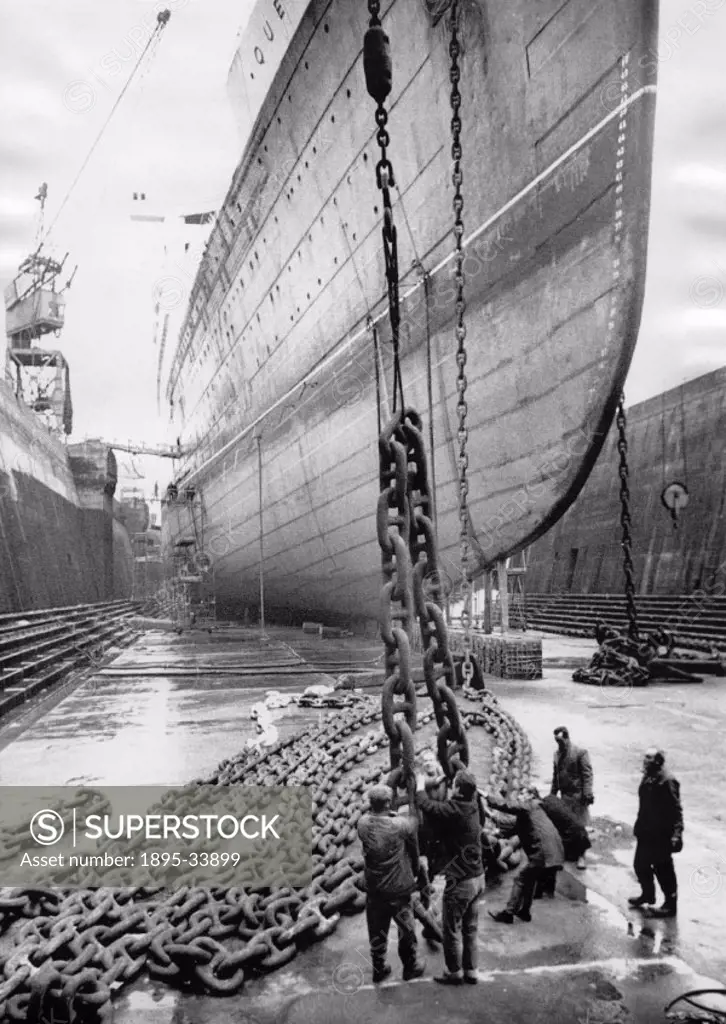 Men working on the huge chain links of the anchor during the ship´s annual winter overhaul. Built at Clydebank for Cunard White Star Ltd in 1936, the ...