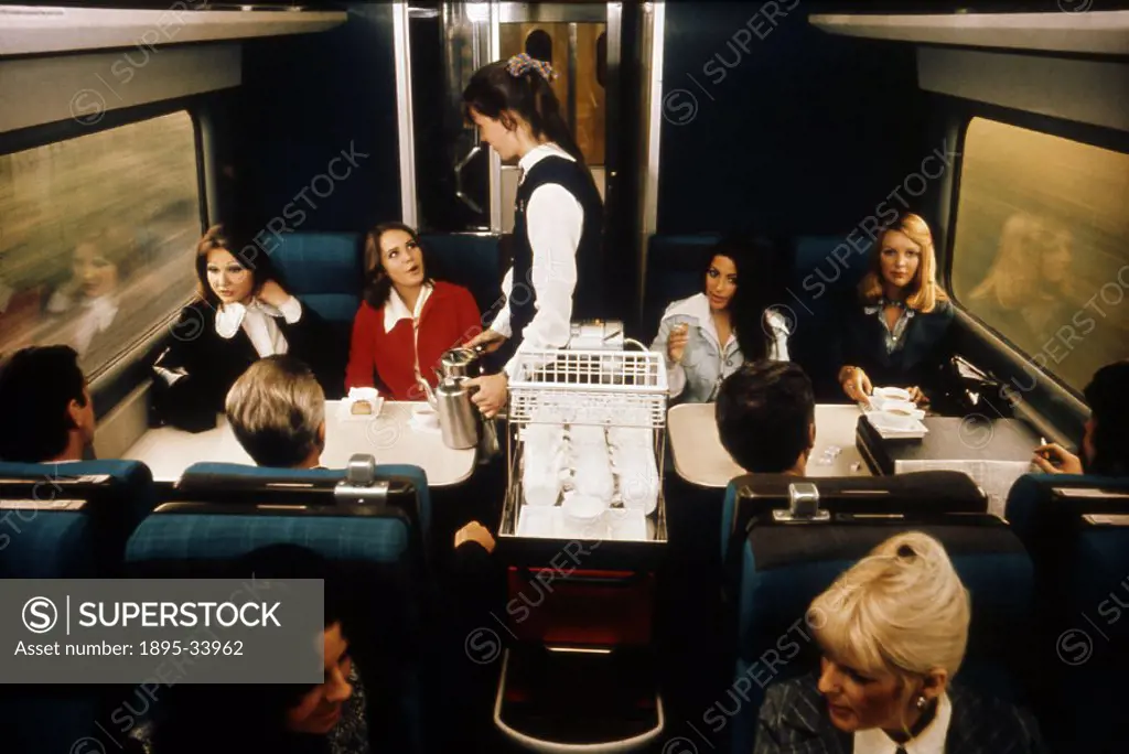 Stewardess serving coffee to smartly dressed passengers, 1975-1985.