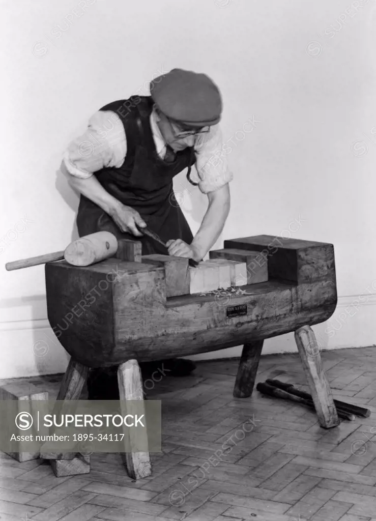 Photograph showing a man scoring grooves with a gorge to create a ship´s pulley block. The development of the pulley block was fundamental to the work...