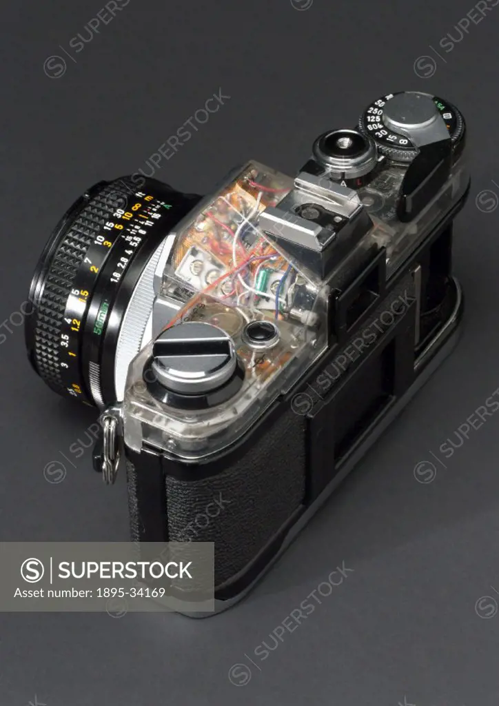 Top rear view of automatic single lens reflex 35mm camera made by Canon, partically cut away to show internal construction.