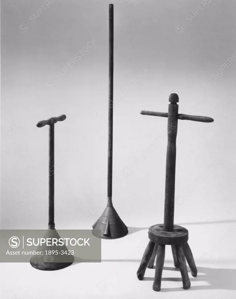 Two metal conical washing dollies and one 6-pronged wooden washing dolly.