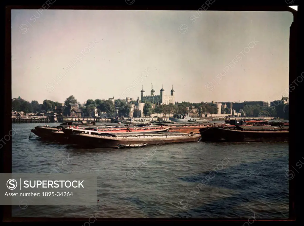 A Dufaycolor colour transparency of barges on the River Thames with the Tower of London in the background, taken by an unknown photographer in about 1...