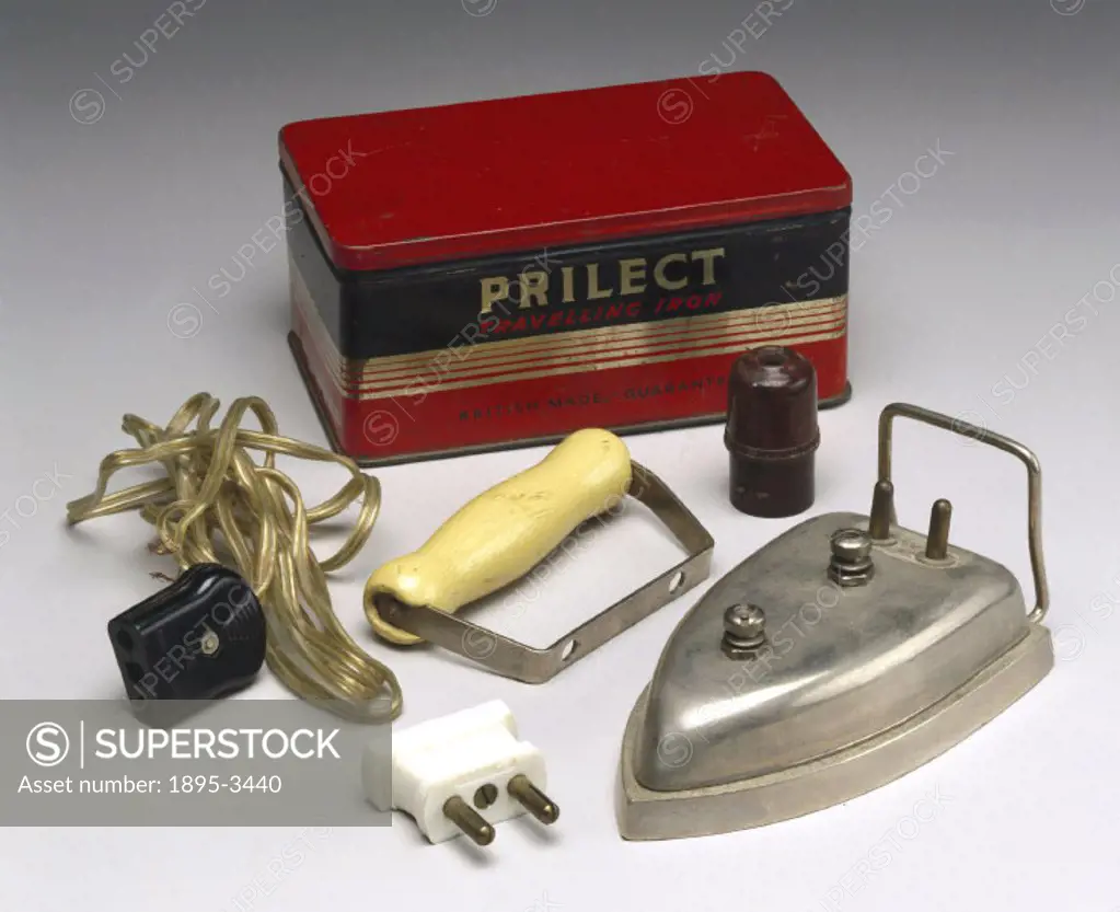 Travelling iron made by T Price and Son Ltd of Aston, Birmingham. The iron is shown with its handle detached, alongside its original storage tin, toge...