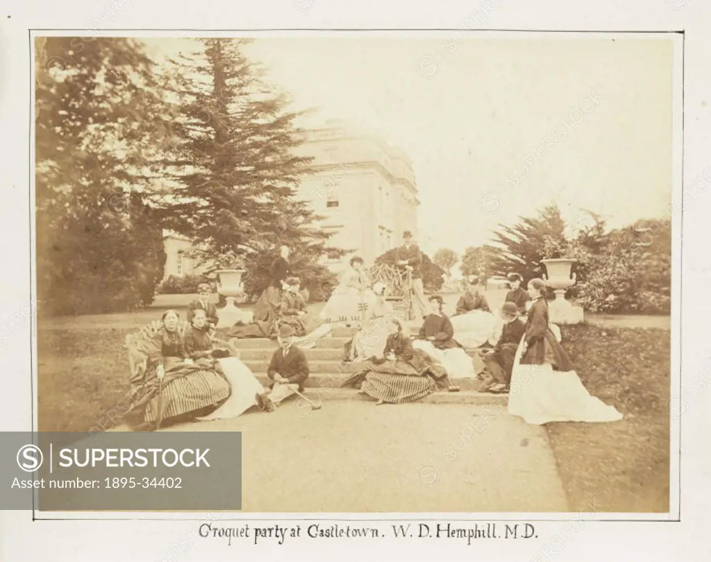 A photograph of a croquet party outside a stately home, taken by W. D. Hephill in 1868. The Castletown of the title is possibly Castletown House in Ki...