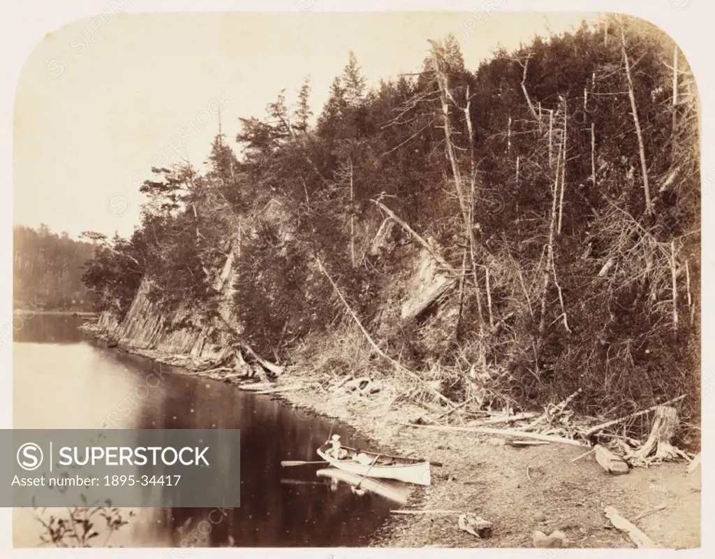 A photograph of a canoe on the shore of a river in the Palisades area of Canada, taken by William McFarlane Notman (1826-1891), in 1860. This photogra...