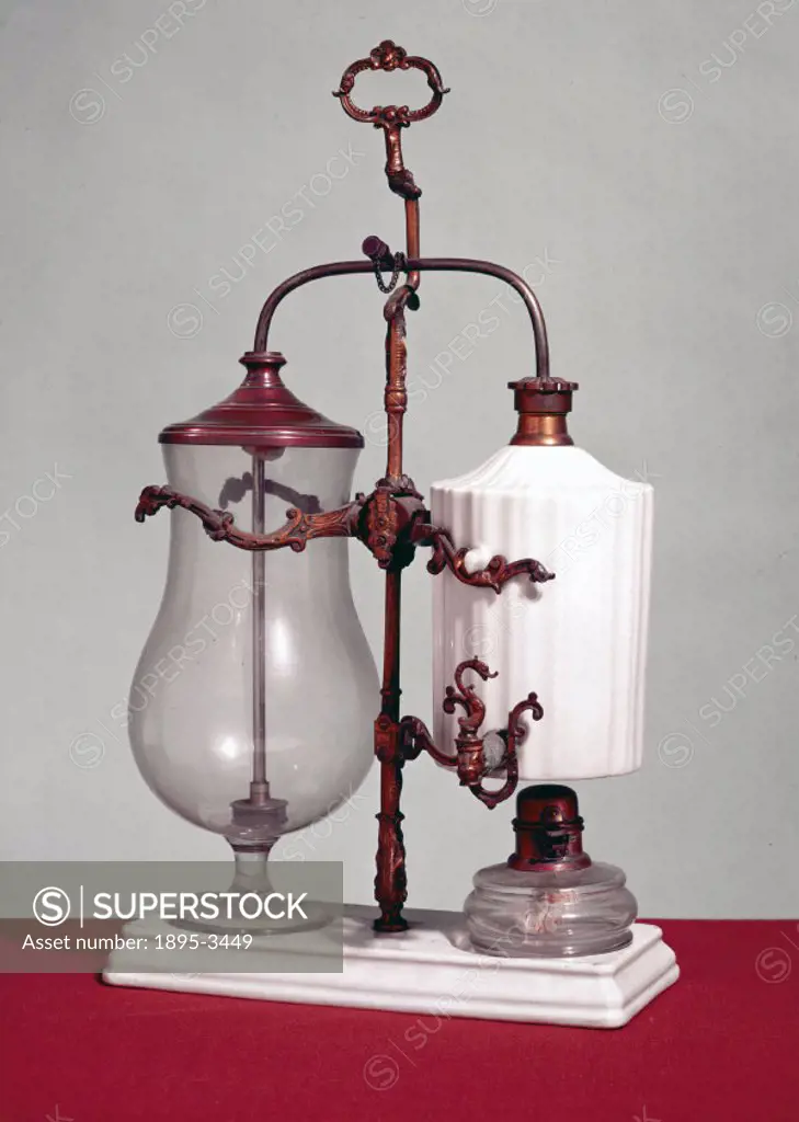 This unusual automatic coffee making machine has a white fluted porcelain water boiler supported above a glass spirit lamp. It is European, probably F...