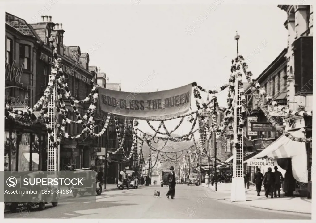 A photograph of a street in Harrogate, Yorkshire, taken by an unknown photographer in May 1937. The street has been decorated to celebrate the Coronat...
