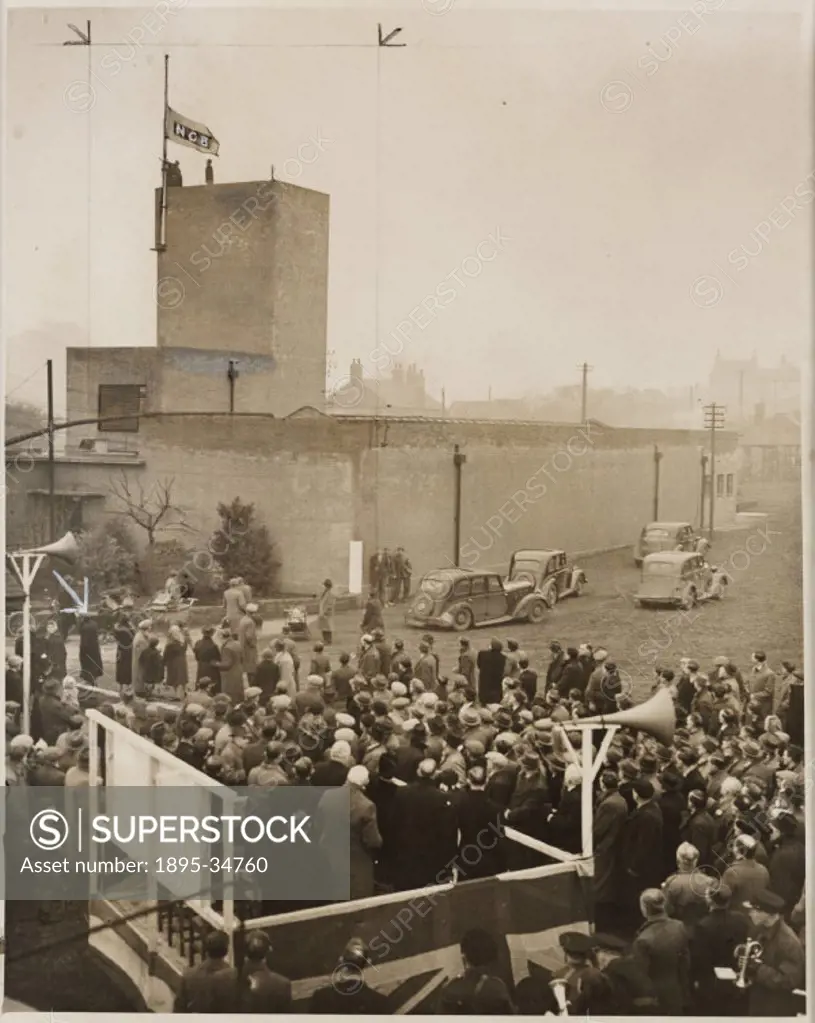 A photograph of miners from Cinder Hill pit in Nottinghamshire watching the National Coal Board flag being hoisted following nationalisation, taken by...