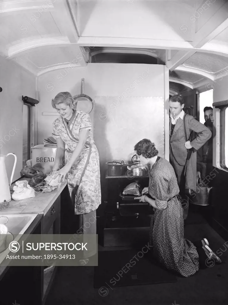 Holiday makers preparing food inside a camping coach, 1936.   Camping coaches were converted railway carriages that families or groups of friends coul...