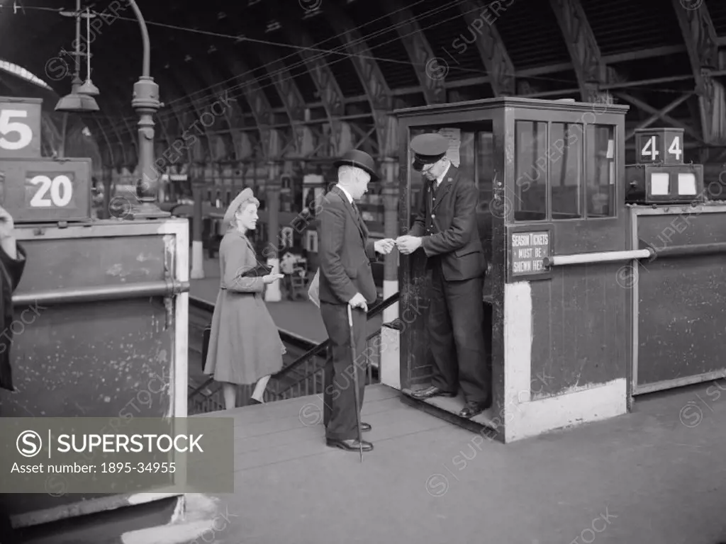 Tickets being checked at Paddington station, 1941.   At this time tickets were examined before passengers boarded the train. They were clipped so that...