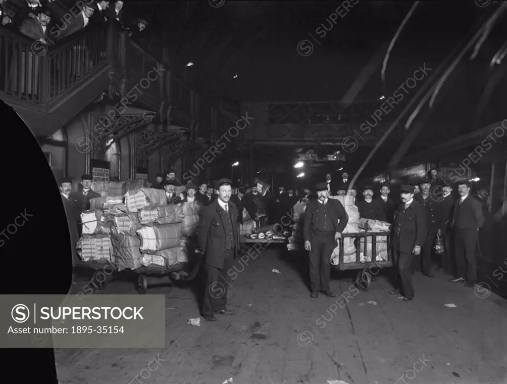 Newspapers being loaded onto a train at Paddington station, 11.30 p.m., 5th February 1910.   By the 1900s newspapers were being carried from the print...