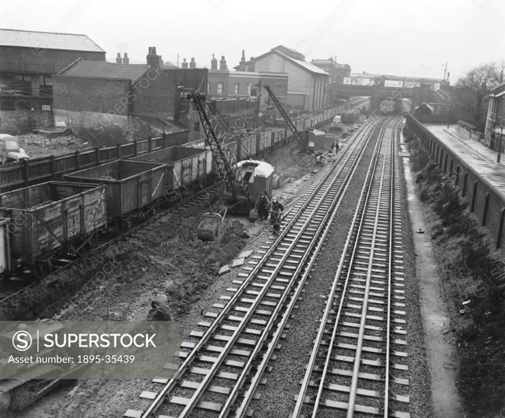 Workers stabilising track at Plaistow, London, 16 December 1956. Track was easier to build and repair by the 1960s than it had been previously due to ...