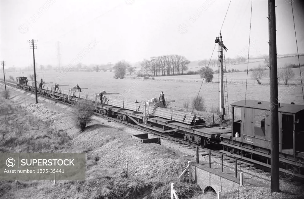 300 foot lengths of railway track on railway wagons at West Horndon, Essex, 31 March 1957.   The workers are relaying the track on the London, Tilbury...