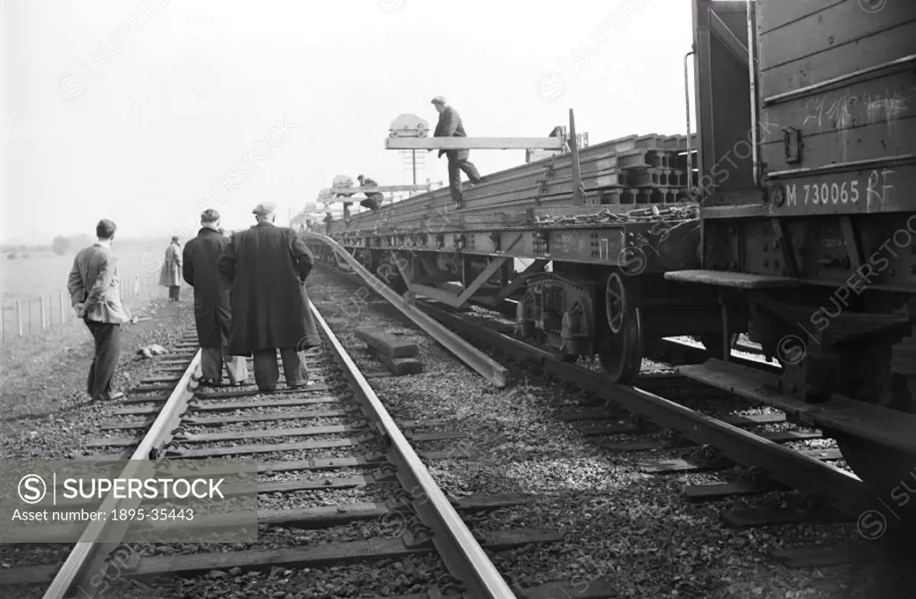 300 foot lengths of railway track being unloaded from railway wagons at West Horndon, Essex, 31 March 1957.   The workers are relaying the track on th...