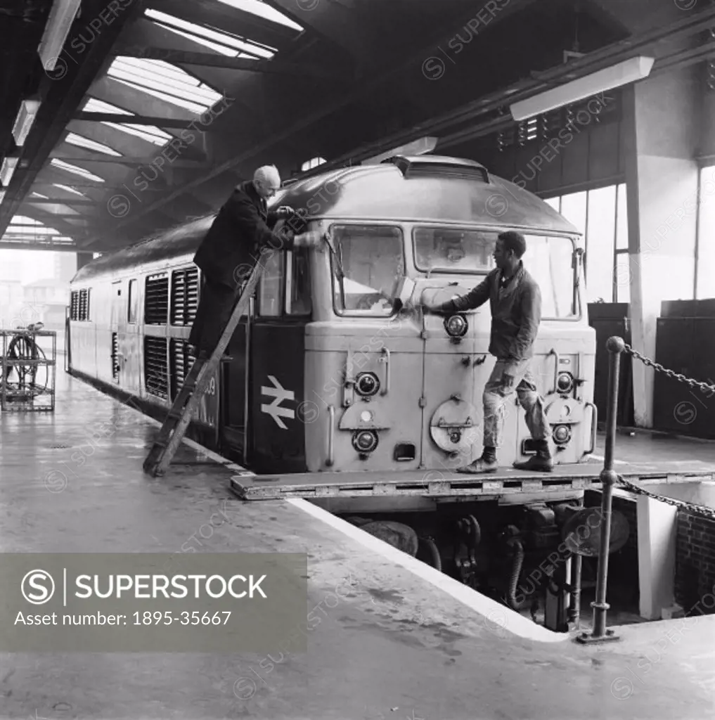 Workers servicing an engine inside Stratford diesel locomotive depot, 26 September 1969.  The depot dealt with broken diesel locomotives. The engines ...