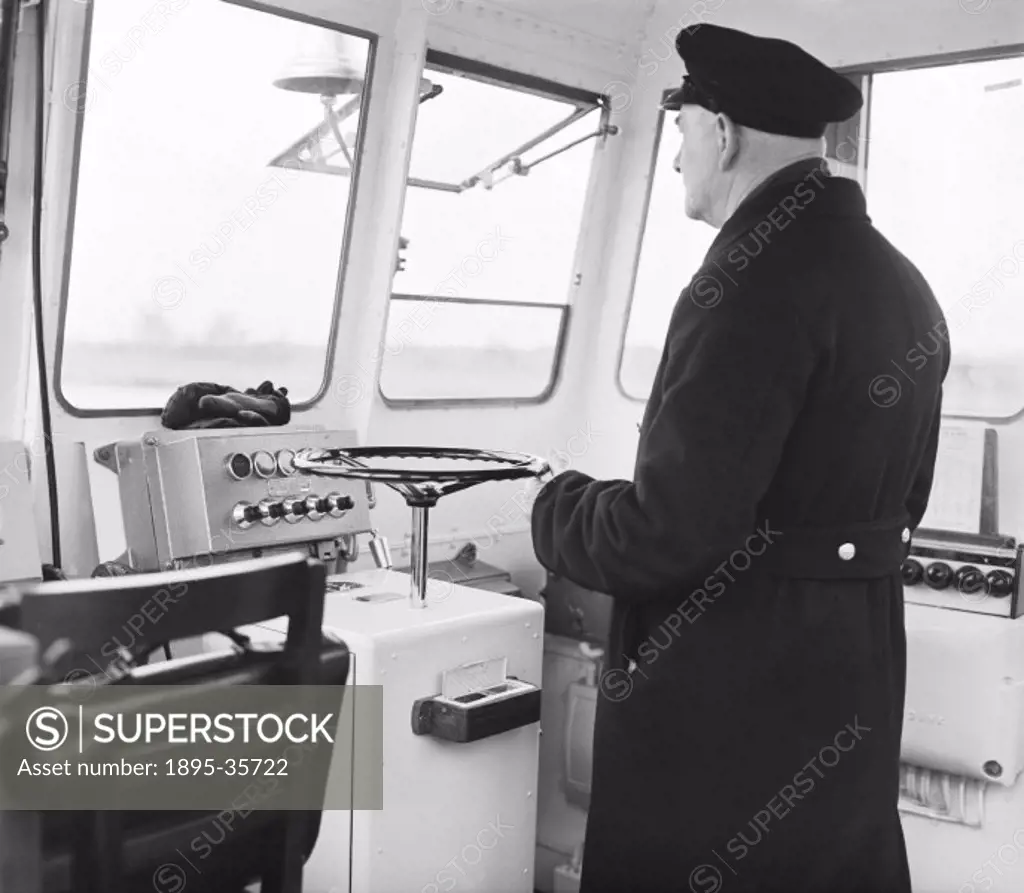 Captain C J Simms in the ferry Catherine’ at Gravesend, Kent. This ferry, built at Cowes by J S White, was used to take passengers across the Thames ...
