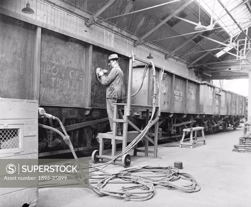 Worker smoothing a door in the scraping shop at Temple Mills wagon works, London, 22 April 1960. Temple Mills wagon works was built in 1896 on the Gre...