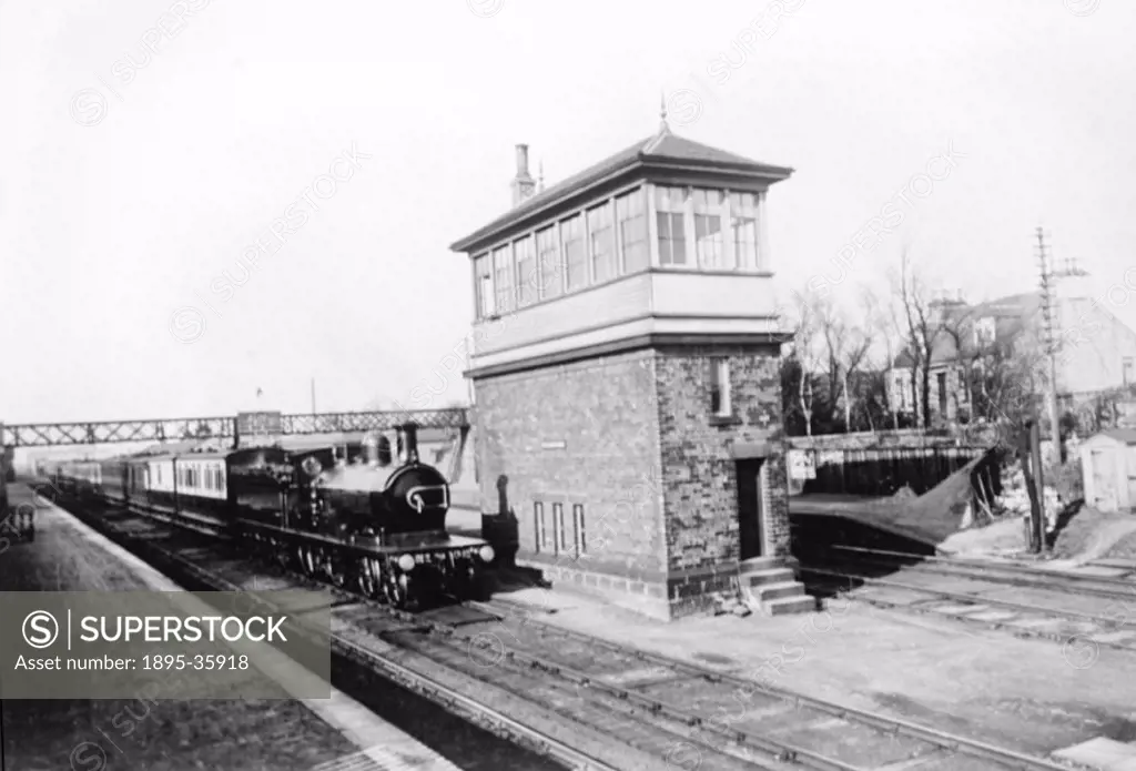 Passenger train, hauled by a 4-4-0 locomotive passing a signalbox at Dyce, on the Great North of Scotland Railway, about 1910.  The GNSR was formed in...
