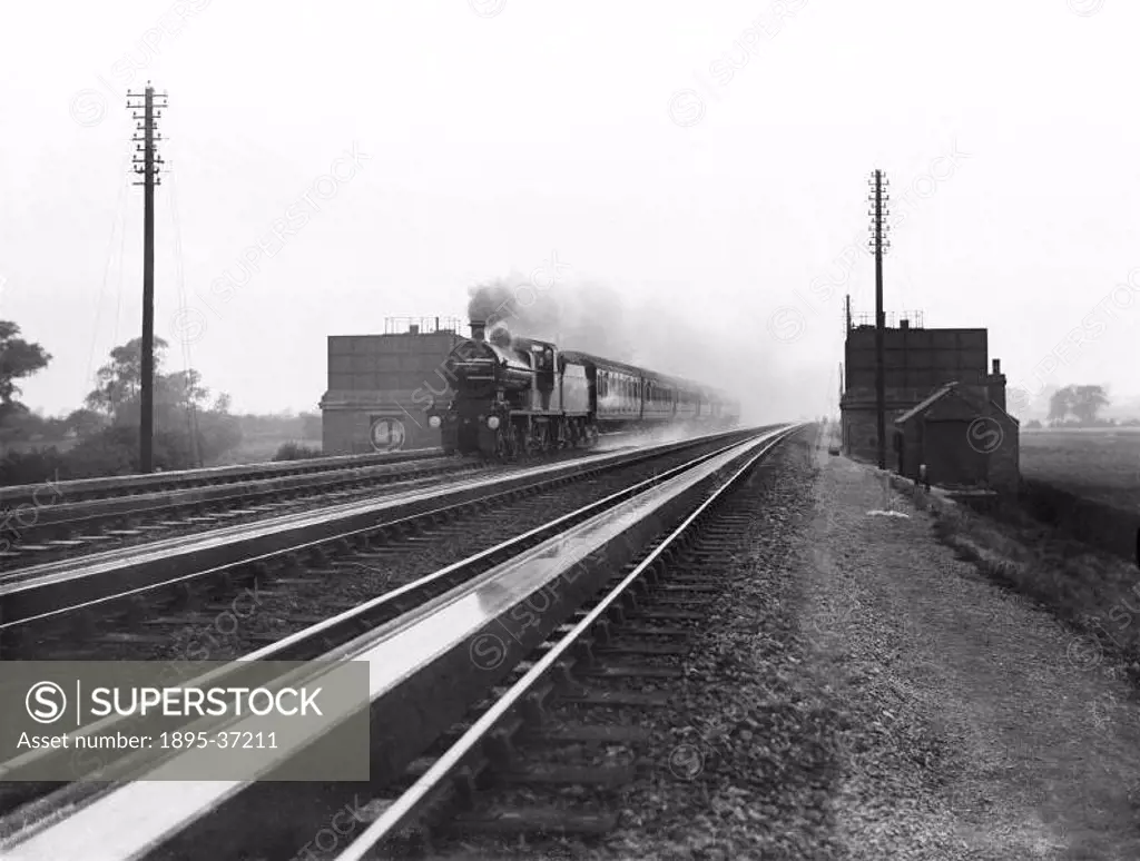 An 4-4-0 locomotive number 998 with a passenger train, receiving water at Loughborough, 26 June 1911.  Locomotives needed to have the water levels in ...