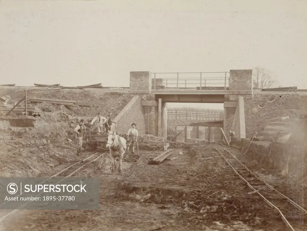 Workers building the Harrow to Uxbridge line, by R Wells, about 1902. The workers have put down a temporary track along which they could pull carts.  ...