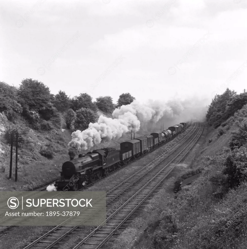 Mixed goods train, pulled by a 4-4-0 locomotive number 42373, by E D Bruton, 8 June 1953. The train is hauling containers, oil tankers and wagons.  Al...