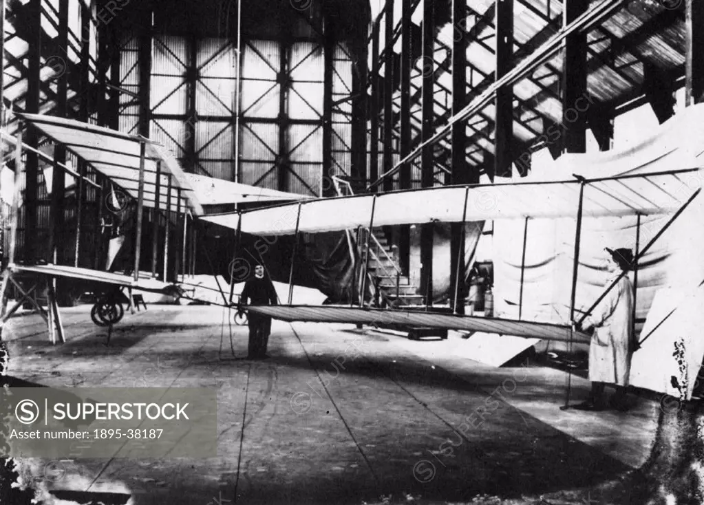 Leon and Vivian Cody are seen manhandling a model glider in the foreground. Taken in the Farnborough airship shed. Samuel Franklin Cody (1861-1913) wa...