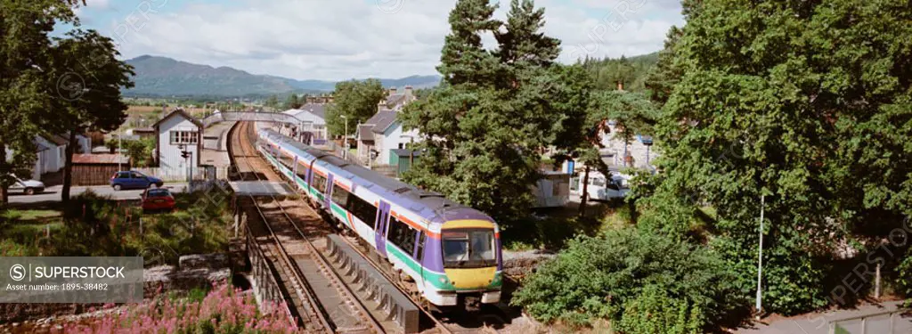 Electric passenger train at Kingussie, on the Highland Main line, by Chris Hogg, August 2002. The Highland Main line stretches from Perth to Inverness...
