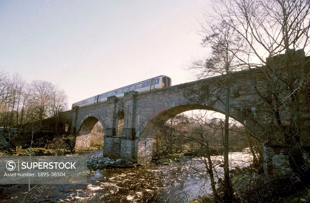 Diesel powered passenger train on Alness Viaduct, Scottish Highlands, by Lynn Patrick, 2001. This viaduct is on the line between Thurso and Inverness....