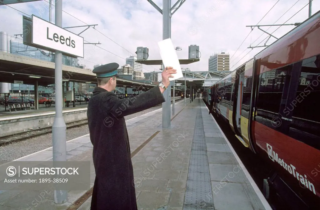 Guard on the platform at Leeds station, by Lynn Patrick, 8 March 2001. The guard´s job is to make sure the platform is clear and all passengers are on...