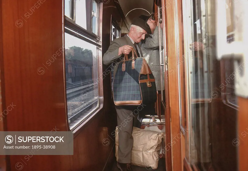 Passenger in a railway carriage corridor, 1963.  At this time many carriages still had compartments, although open plan carriages were becoming more c...