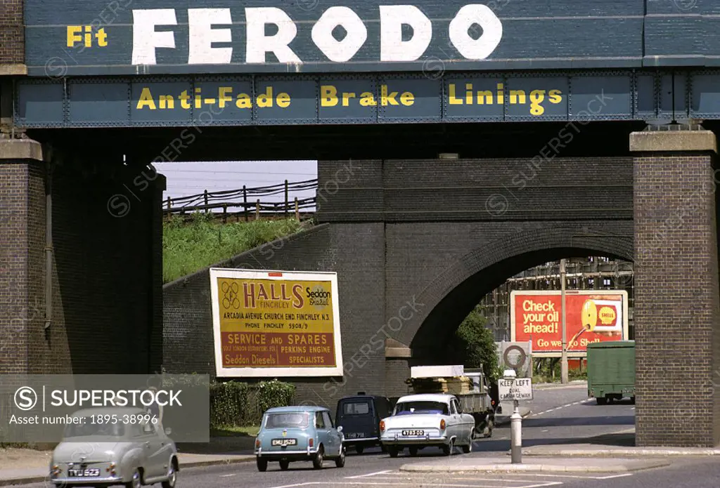 Cars under a bridge in London, advertising car brake linings, 1965.   Adverts for car parts and petrol were becoming more common at this time, as road...