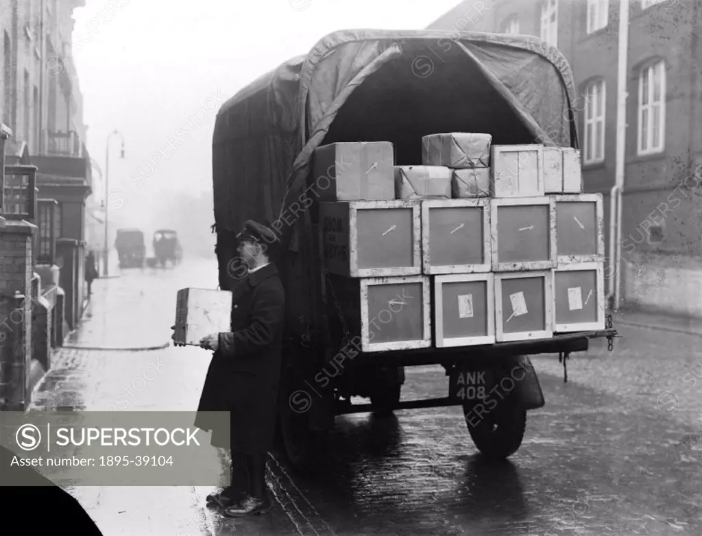 Boxes being unloaded from a van to a house on a wet day, 1935.  It was common to use the railways when moving house. Furniture was loaded into a conta...