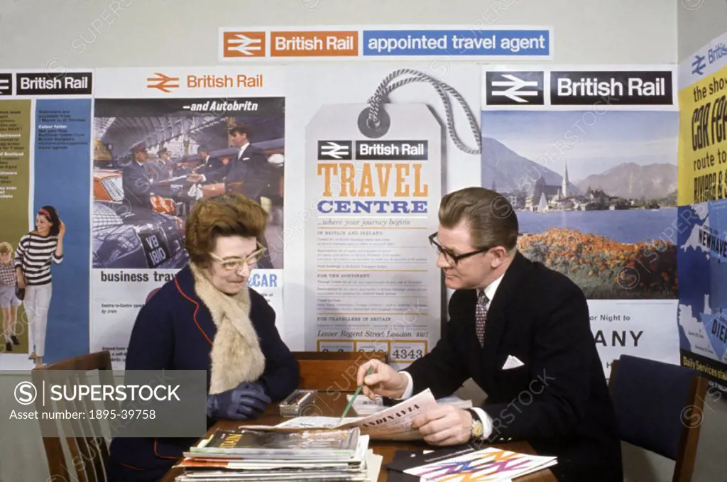 Passenger and British Rail worker in a station travel centre, 1964.  This photograph was taken to show a new British Rail symbol, which is shown in th...