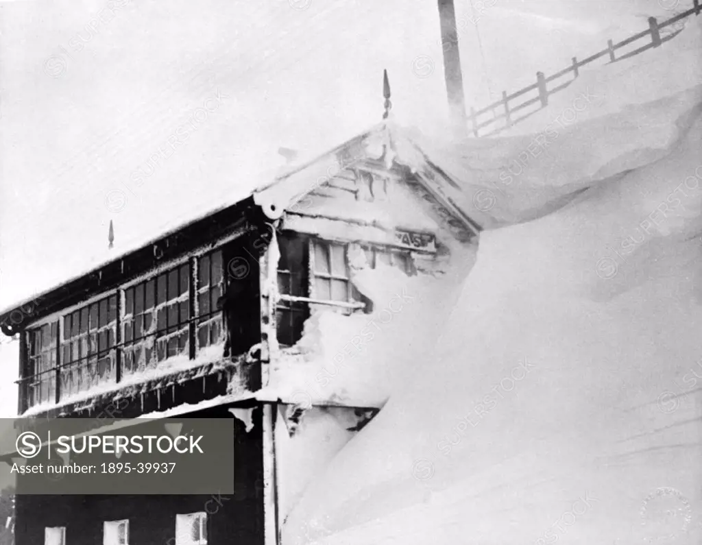 Signal box, covered in snow, about 1935.  Snow is a particular hazard to the railways, because it can come suddenly and can drift quickly, burying tra...