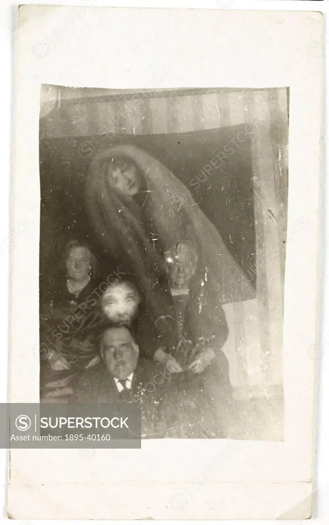 A photograph of a man and two women, possibly taken by William Hope (1863-1933). Two faces appear around the group - one, an elderly person, and the o...