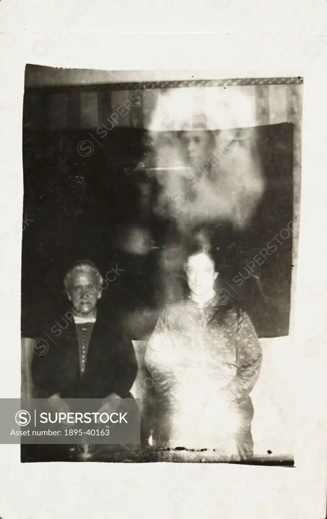 A photograph of two women, possibly taken by William Hope (1863-1933). A woman´s face appears above the heads of the women, surrounded in an ethereal-...