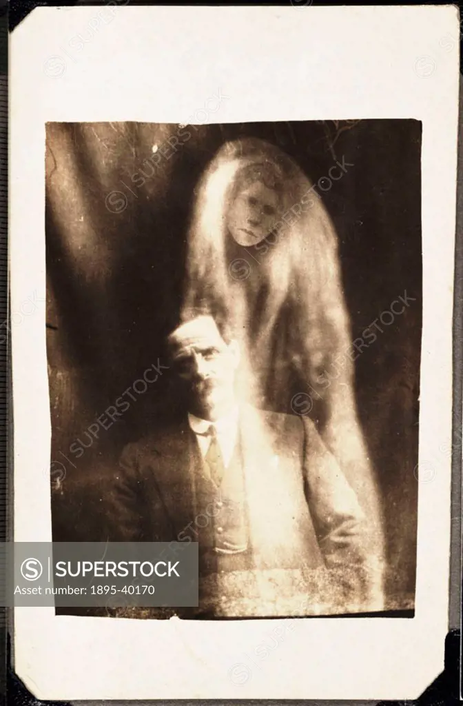 A photograph of a man, taken by William Hope (1863-1933).  A woman´s face appears in ´misty´ drapes around the man. He was said to have been asked to ...