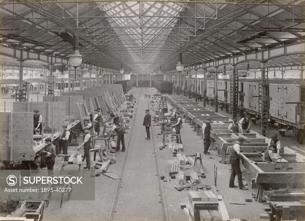 Workers making wagons at Doncaster carriage and wagon works. At this time wagons were made from wood. The parts for the wagons are laid out in the for...