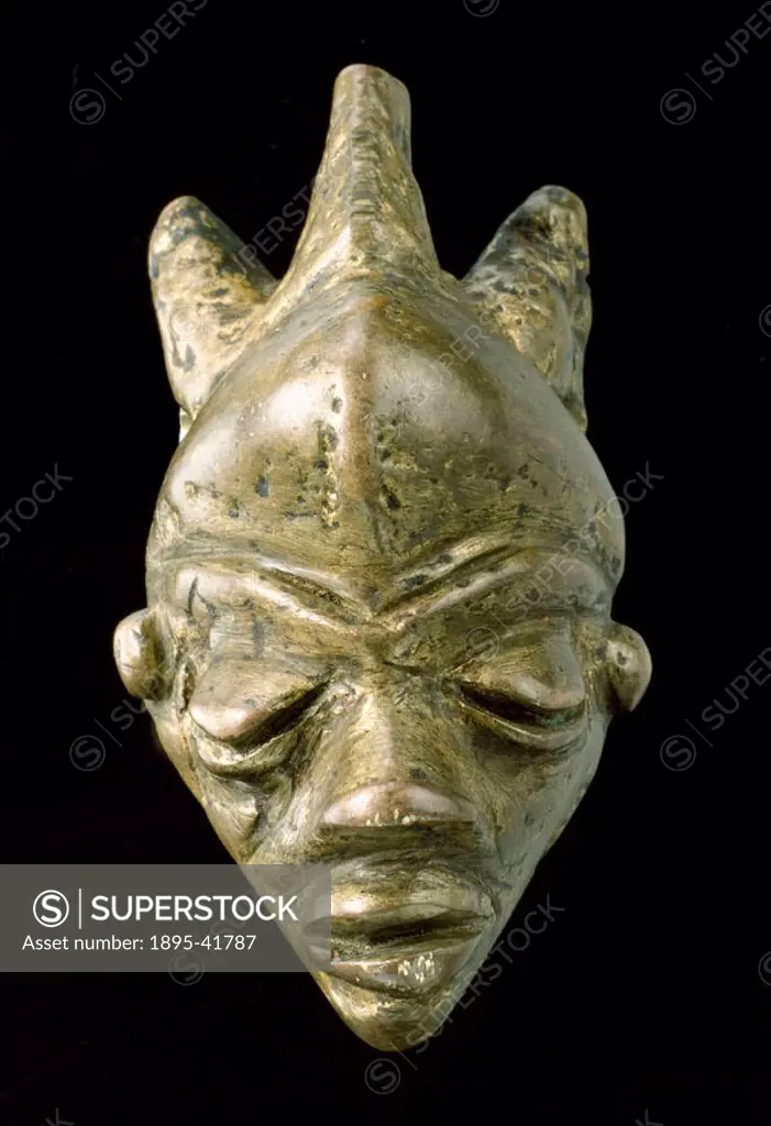 Brass amulet in the form of a face, made by the Bapende tribe.