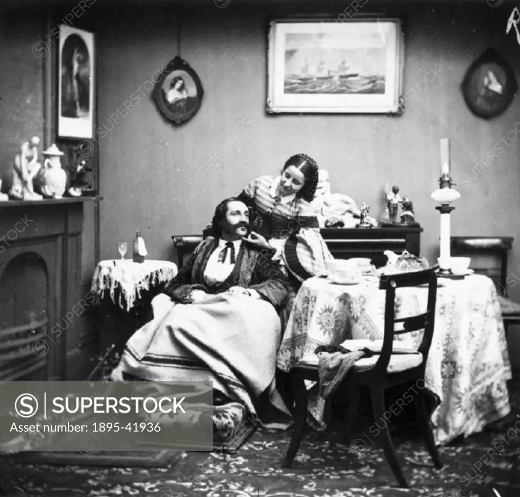 Victorian scene with a man wrapped in a blanket, a bottle of medicine on the table beside him. His wife bends over him solicitously.